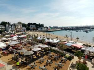 eine Luftansicht auf einen Strand mit Tischen und Sonnenschirmen in der Unterkunft la petite maison du Portrieux in Saint-Quay-Portrieux