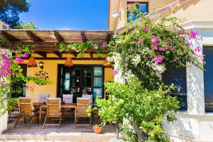 eine Terrasse mit einem Tisch, Stühlen und Blumen in der Unterkunft Villa Abaesko by Rock Rentals in Jávea