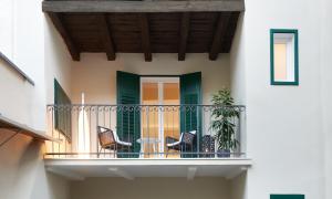patio z krzesłami i stołem na balkonie w obiekcie Cityflair Boutique Apartments w mieście Bolzano