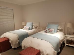 a bedroom with two beds with pillows on them at Drome (Eng Dreams) in Gansbaai