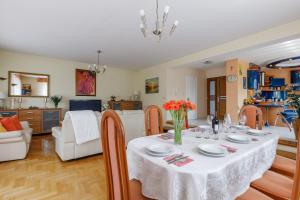 a dining room and living room with a table and chairs at Willa Biała Magnolia in Nowy Targ