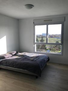 a bedroom with a bed and a large window at Appartement Futuroscope-J' in Jaunay-Marigny