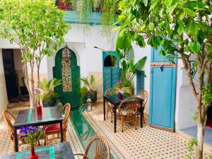 a patio with tables and chairs and trees at Riad 11 Zitoune in Marrakech