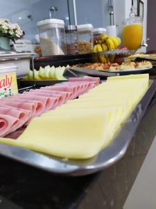 a buffet with ham and cheese on a table at Flex Hotel in Três Lagoas