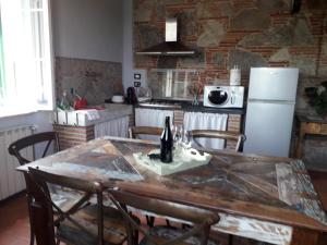 ルッカにあるCasa De Serviのキッチン(木製テーブル、椅子、冷蔵庫付)