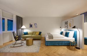 een weergave van een slaapkamer met een bed en een bank bij Cityflair Boutique Apartments in Bolzano