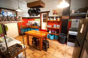 a kitchen with a table and a refrigerator at MaPatagonia Hostel in Puerto Varas