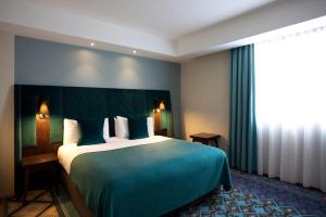 a hotel room with a large bed and two lamps at Mercure London Bridge in London