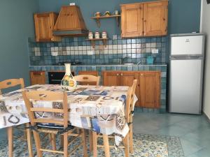 カステッランマーレ・デル・ゴルフォにあるSicania holiday house 1のキッチン(テーブル、椅子、冷蔵庫付)