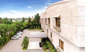 Vista al árido de un edificio con coches aparcados en un aparcamiento en Islamabad Regalia Hotel, en Islamabad