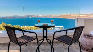 - deux verres de vin assis sur une table sur un balcon dans l'établissement Akrotiri Apartments, à Akrotiri