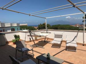 een patio met stoelen en een hangmat op een dak bij Casa Bice Amazing view of Vesuvius in Sorrento