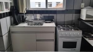cocina con fregadero y fogones en Apartamento Residencial Messina, en Florianópolis