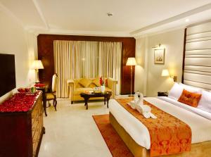 a hotel room with a bed and a living room at Islamabad Regalia Hotel in Islamabad +36 photos