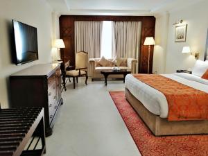 a hotel room with a bed and a living room at Islamabad Regalia Hotel in Islamabad