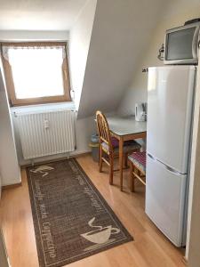 a small kitchen with a table and a refrigerator at Gemütliche Fewo Angela 5 im Westerwald in Bad Marienberg