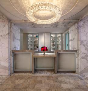 a bathroom with a large mirror and a table at The Peninsula Beverly Hills in Los Angeles