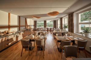 a restaurant with wooden tables and chairs and windows at Hotel Vogtland in Bad Elster