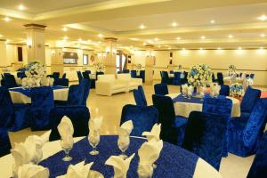 a banquet hall with blue chairs and tables with flowers at Islamabad Regalia Hotel in Islamabad