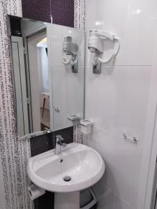 a white bathroom with a sink and a mirror at Guest House Harmony in Veliko Tŭrnovo