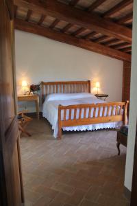 a bedroom with a large wooden bed and two tables at Agriturismo Poggio Della Rosa in Amelia