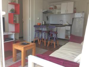 a living room with a couch and a kitchen at Apartamentos Armando in Santiago