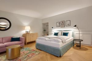 una camera con un grande letto e un divano viola di Cityflair Boutique Apartments a Bolzano