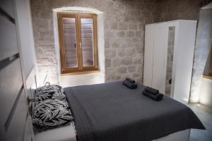 Schlafzimmer mit einem Bett und einem Fenster in der Unterkunft Limestone Heritage House in Trogir