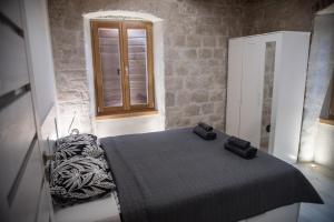 een slaapkamer met een bed en een raam erin bij Limestone Heritage House in Trogir