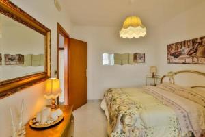 a bedroom with a large bed and a mirror at B&B Villa luisa in San Mango Piemonte
