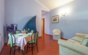 a dining room with a table and chairs and a couch at Cottage Castelletto in Sinalunga