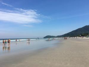 a group of people walking on the beach at Suites Praia de Juquehy in Juquei