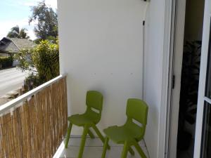 two green chairs sitting on a balcony at Apartment Studio Halfon in Moorea