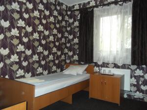a bedroom with a bed with a floral wallpaper at Pensiunea Contour in Iaşi +17 photos