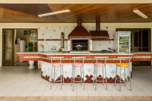 una cucina con bancone e sgabelli da bar di Pousada Lozalti a Florianópolis