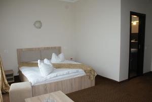 a bedroom with a bed with white sheets and pillows at TROPHAEUM TRAIANI in Adamclisi