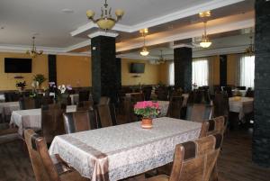 a dining room with a table and chairs with flowers on it at TROPHAEUM TRAIANI in Adamclisi