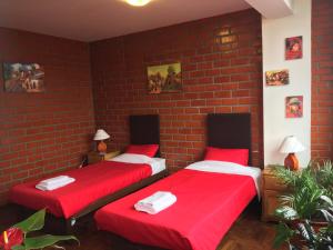 two beds in a room with a brick wall at Miraflores Centre in Lima