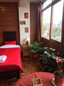 a bedroom with a red bed and potted plants at Miraflores Centre in Lima +22 photos