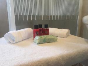 a bathroom counter with towels and two bottles ofodorizers at Camellia Chalet in Germoe