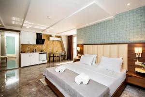 a bedroom with a large bed with towels on it at Margi Boutique Hotel in Tbilisi City