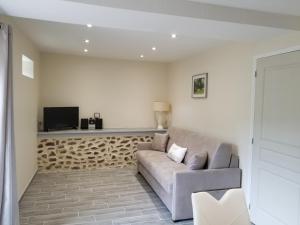 a living room with a couch and a tv at GITE CHOUCHOU in Izé