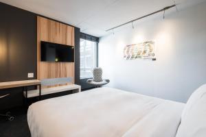 una camera con letto bianco e TV di Alt Hotel Ottawa a Ottawa