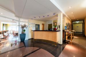 a lobby with a bar in the center of a building at Hotel am Stadtgarten in Radolfzell am Bodensee