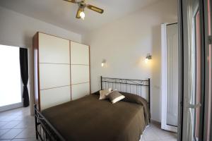 a bedroom with a large bed and a ceiling fan at Agriturismo La Tuffatrice in Imperia