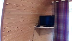 uma televisão numa prateleira numa parede de madeira em Carnamuff Glamping em Ballykelly