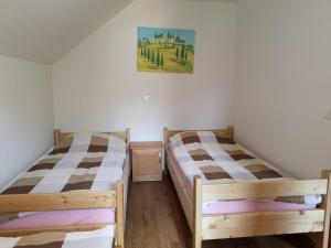 - une chambre avec 2 lits et une photo sur le mur dans l'établissement Apartments Trebušak, à Laze v Tuhinju