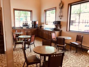 a restaurant with tables and chairs and a kitchen at Shenandoah Inn & Suites in Shenandoah