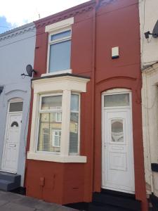 een rood gebouw met twee ramen en een deur bij Hinton House in Liverpool