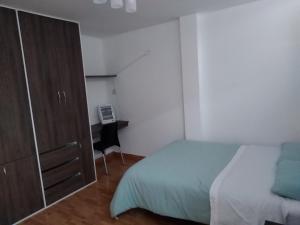 sypialnia z łóżkiem, komodą i biurkiem w obiekcie Departamento en el centro de San Borja (Rubens) w mieście Lima